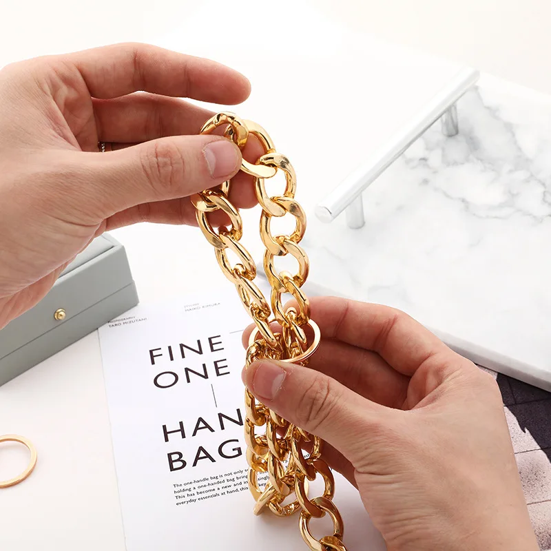 Wide metal chain links held by hand