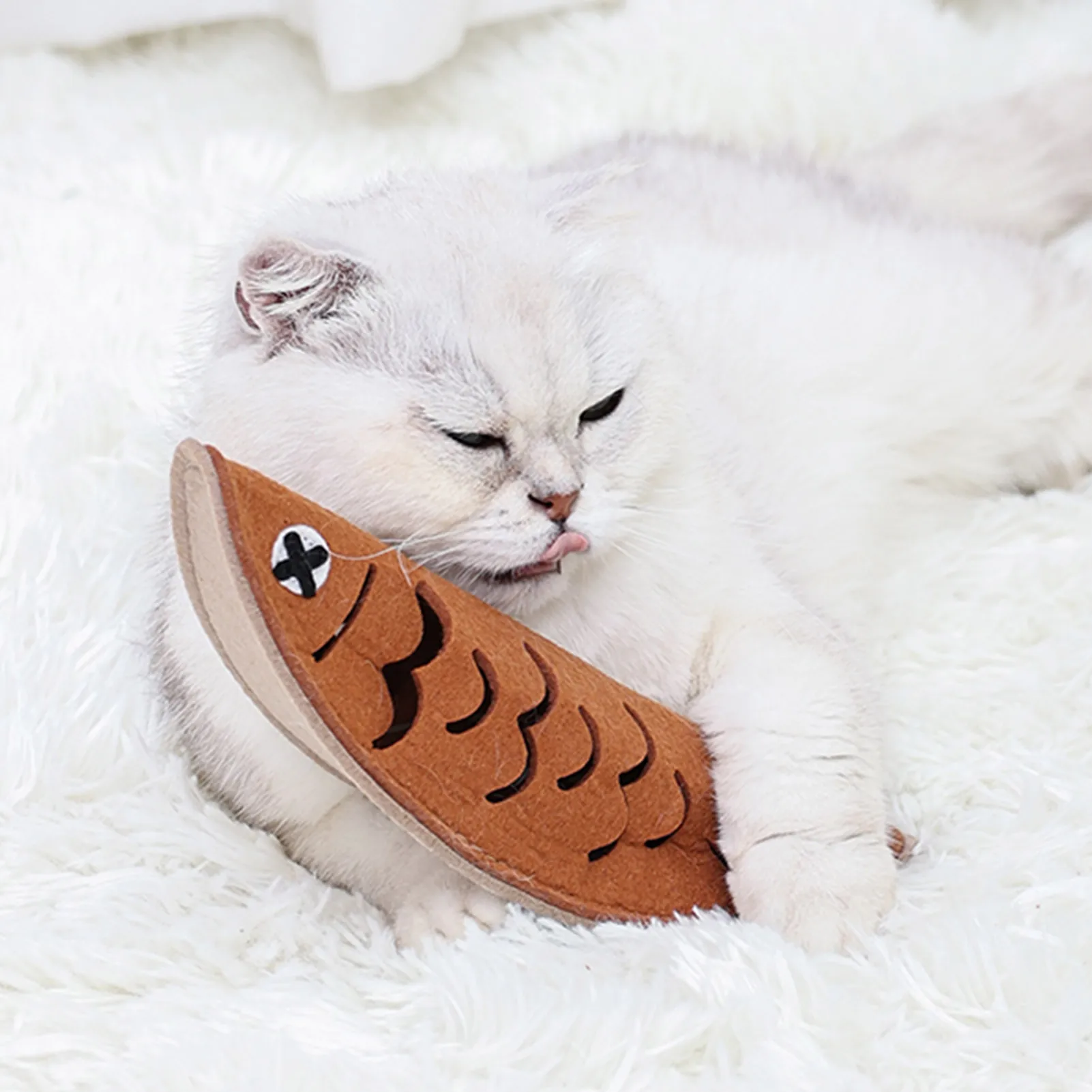 Cat playing with the felt fish toy