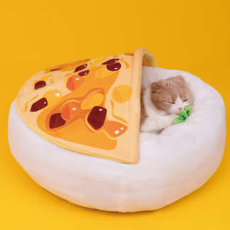 Cat resting beneath the curry-print cover of a plush bed
