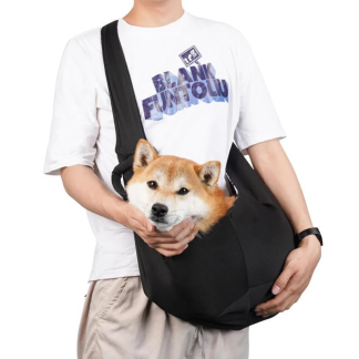Small dog sitting in a black shoulder sling carrier