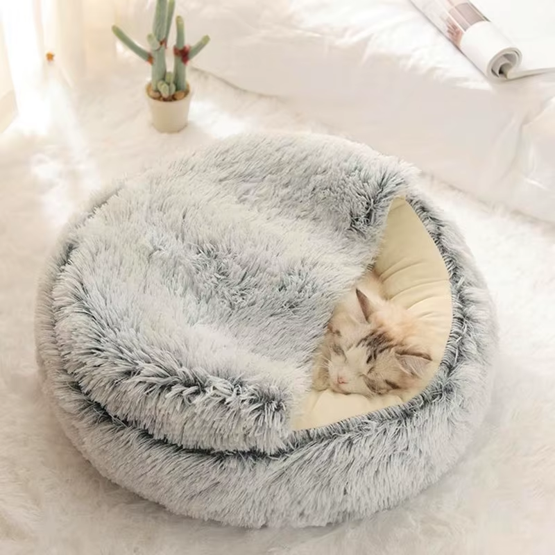 Cat curled beneath the hood of a grey pet bed