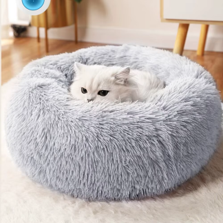 Cat curled in a grey round plush pet bed